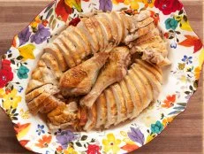 Overhead shot of carved Make Ahead Thanksgiving Turkey on floral platter