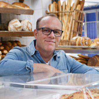 Host Tom Papa poses at Gian Piero Bakery, as seen on Baked with Tom Papa, Season 1.