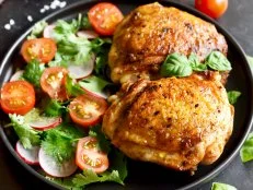 Fried chicken thighs with vegetables in plate