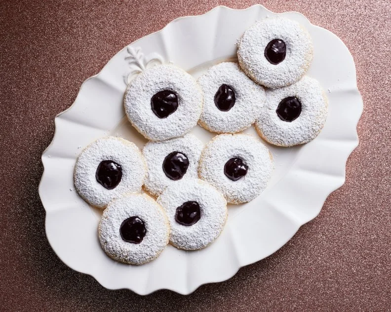 Description: Food Network Kitchen's Linzer Thumbprints. Keywords: Almond Flour, Egg, Sugar, Almond Extract, Raspberry Jam, Powdered Sugar