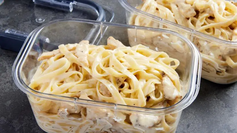 Photo showing  finished chicken fettuccini alfredo in two meal prep containers, lined up, no lids, for the Fettucini Alfredo recipe, as seen on Food Network.