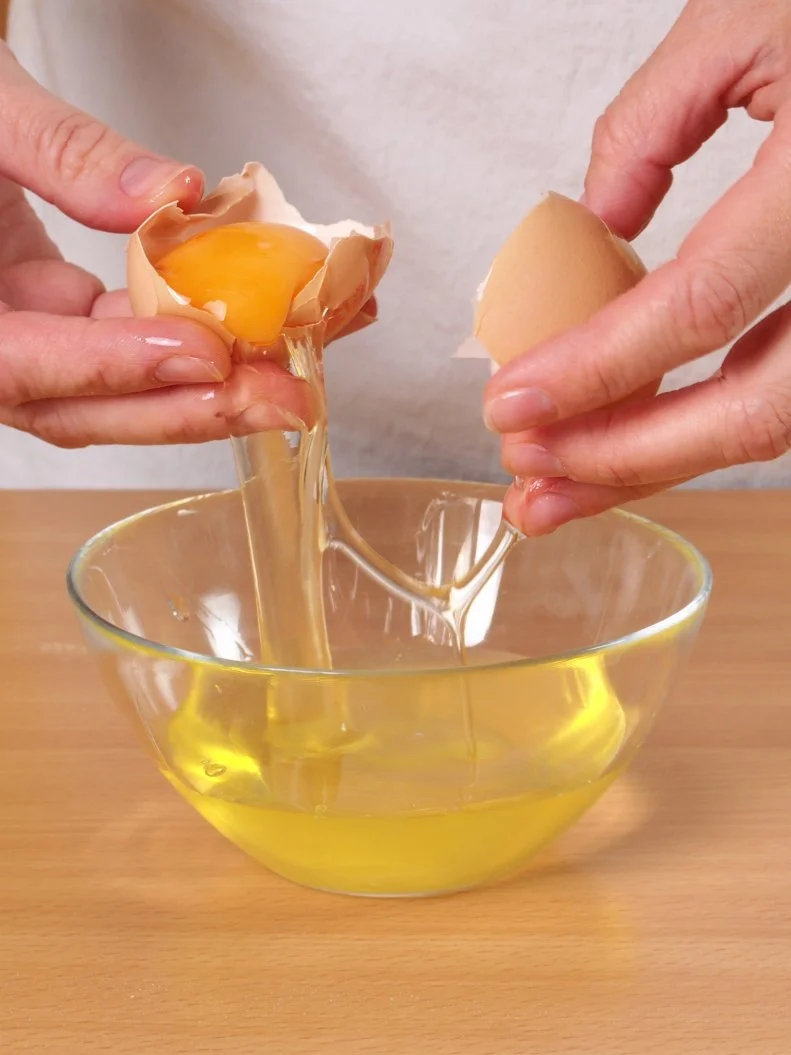 Separating egg yolk from white. Making Chocolate Layer Cake with Cream Cheese Filling and Chocolate Topping. Series.