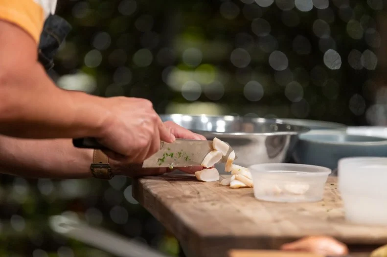 Viet Pham chopping chicken thighs on Bobby's Triple Threat