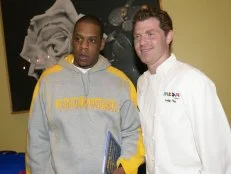 DECEMBER 11:  Rapper Jay-Z joins chef Bobby Flay at his restaurant, Mesa Grill, for the NBA's "Read to Achieve" program. The campaign helps children to develop a love for reading and encourages adults to read to regularly to children.  