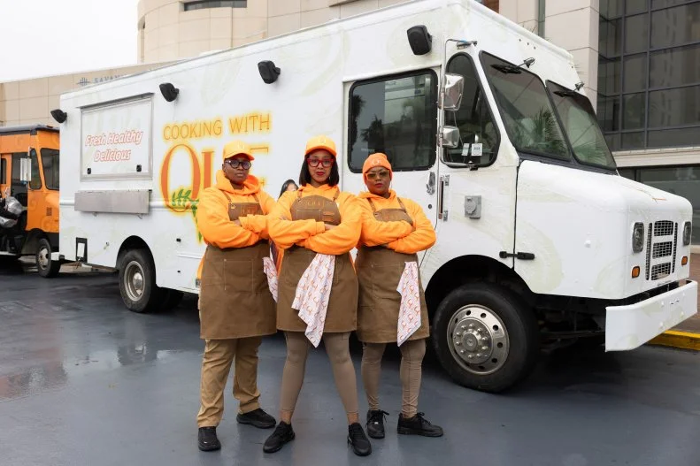 Cooking With Que team members in front of their food truck